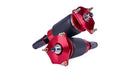A pair of black and red sleeve style automotive air springs with monotube shocks.