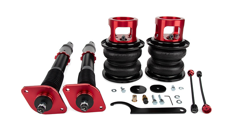 A pair of Air Lift Performance anodized red aluminum accented monotube shocks with double bellows progressive rate air springs with roll plates and remote damping extenders along with fitting hardware. Air suspension part kit