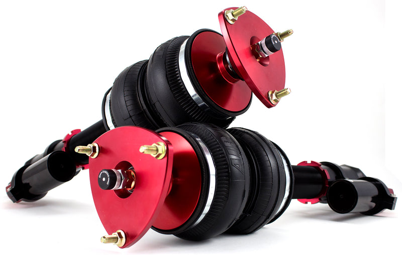 A pair of Air Lift Performance red accented monotube struts with independent adjusters for compression and rebound damping as well as piggyback style nitrogen canisters, and compact double bellows progressive rate air springs. Air suspension kit part
