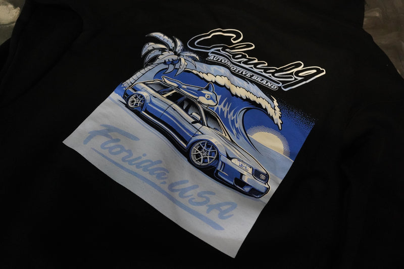 Close up view of the back of the black hoodie showing the blue Audi Florida USA graphic with the Cloud 9 Automotive Brand logo.