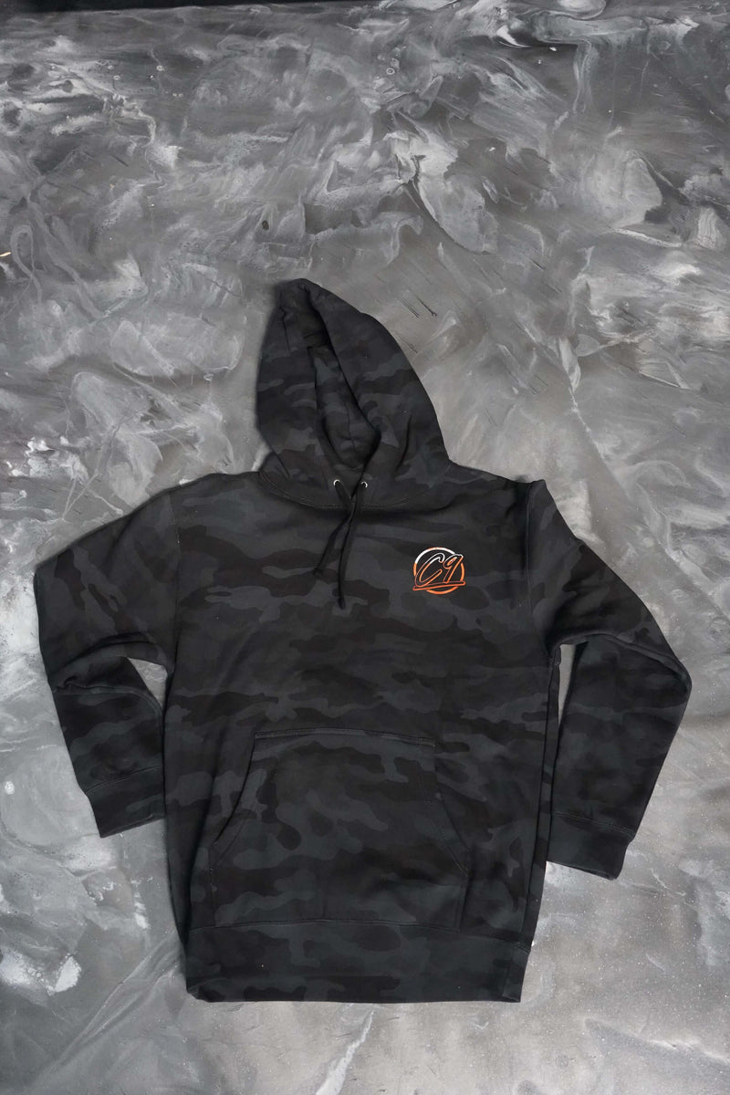 Front of a gray camo hoodie with an orange and white round Cloud 9 Automotice Brand logo below the left shoulder.