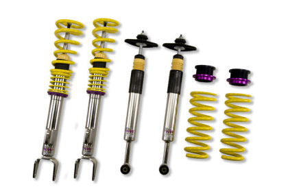 2 vehicle suspension chrome body coilovers with yellow springs and purple accented fittings, 2 chrome abd black bodied coilovers with black fittings, 2 yellow springs and 2 black and purple fittings.