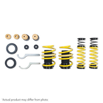 Four yellow vehicle suspension lowering springs with fitments and tool