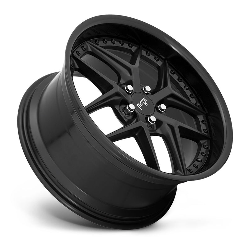 Tilted side view of a Niche Vice monoblock cast aluminum  5 V shape spoke automotive wheel in a gloss black matte black finish with a bolt design on the inner lip and a Niche logo center cap.