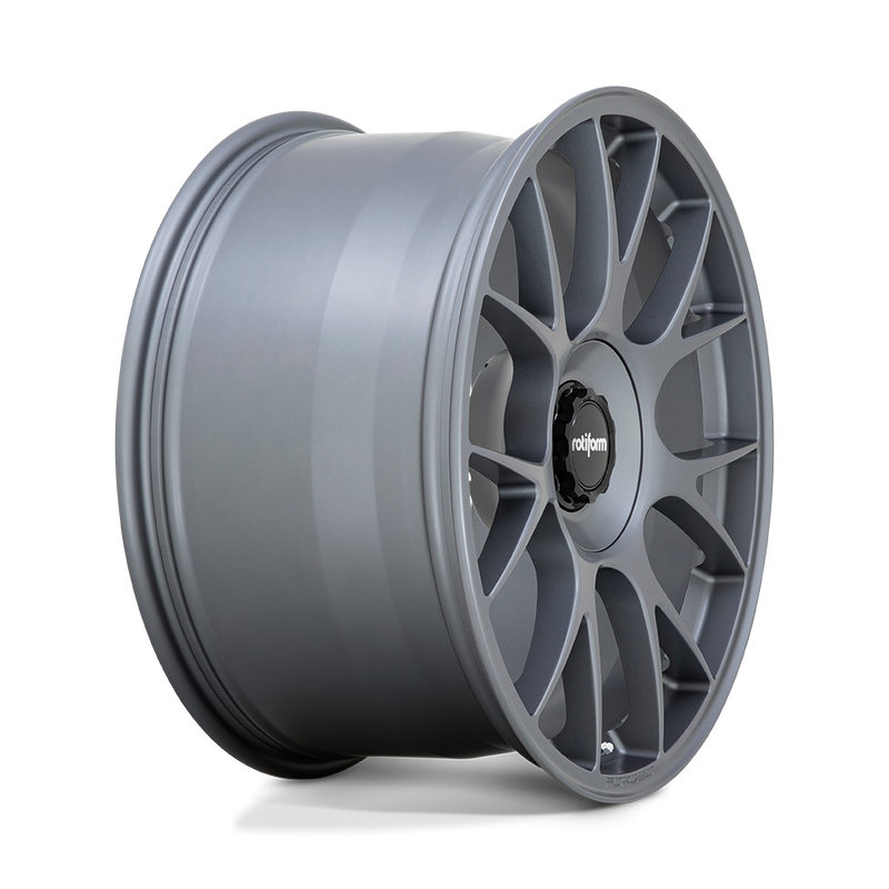 Side view of a Rotiform TUF a monoblock forged aluminum 7 Y shape spoke automotive wheel in a satin titanium finish with the word Forged embossed in the bead ring and a black center cap with a silver Rotiform logo.