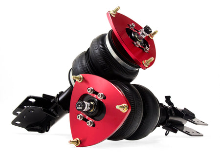 2 air suspension struts with black double bellow air bags with red accented camber plates and black mounting brackets.
