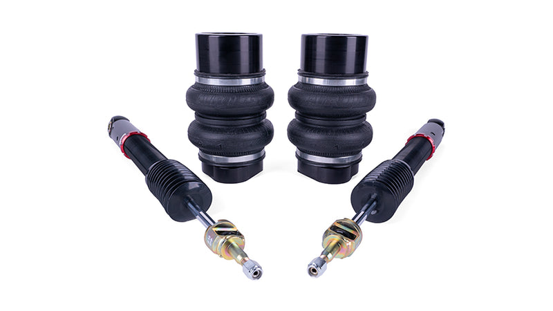 A pair of black double bellow air bags and a pair of black monotube shocks.