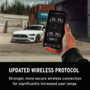 Hand holding a smartphone with a wireless control app, white car in the background