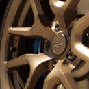 Close-up of a satin bronze alloy car wheel rim with 'RS' logo on the center cap.
