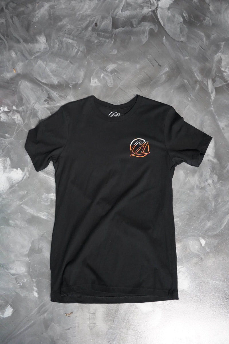 Front of a black T-shirt with the round orange Cloud 9 Automotive Brand logo below the left shoulder. 