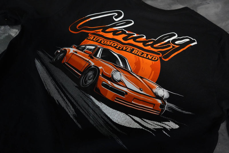 Close up view of the orange Porsche graphic with the Cloud 9 Automotive Brand logo on the rear of a black T-shirt.