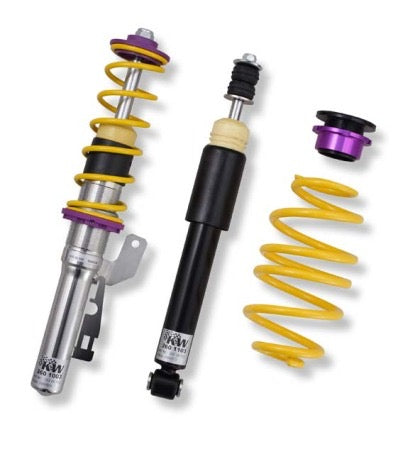 1 vehicle suspension chrome body coilover with yellow spring and purple accented fittings, 1 black body coilover, 1 yellow spring and 1 black and purple accented fitting.