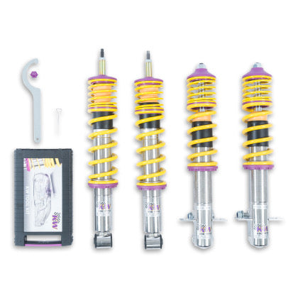 4 assembled vehicle suspension chrome body coilovers with yellow springs and accented with purple fittings, 1 coilover adjustment tool and storage box.