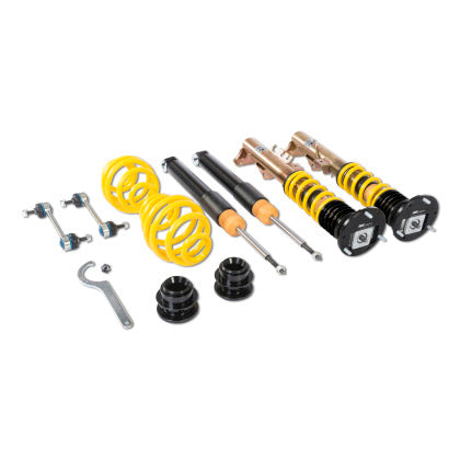 Vehicle suspension coilovers ov ers, two assembled and two unassembled showing black strut without sleeve and spring separately, end links and tool.
