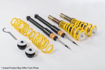 Vehicle suspension adjustable coilover kit showing two assembled coilovers and two unassembled with black strut and spring shown separately, end fittings and tool