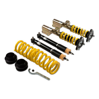 Two assembled adjustable vehicle suspension coilovers, two unsleeved black coilover struts and one yellow spring with end fitments and tool.
