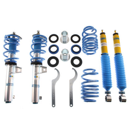2 chrome bodied vehicle coilovers with blue springs and blue strut sleeves, 2 yellow bodied coilovers with blue strut sleeves, 2 blue springs, 2 adjustment tools and a number of fittings.