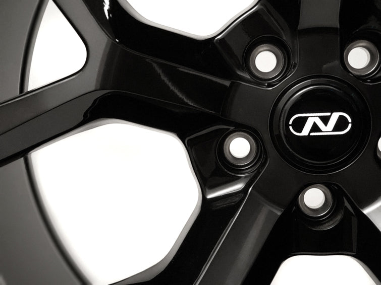 Close up of a Neuspeed lightweight 10 spoke automotive alloy wheel in a gloss black platinum finish.