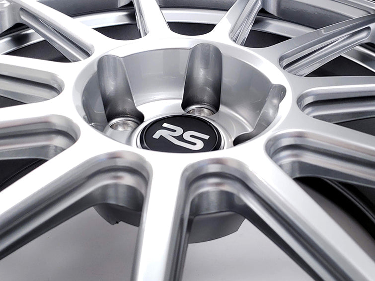 Close up of the RS logo center cap and lug holes on a Neuspeed automotive alloy wheel in a silver finish.