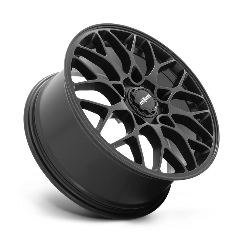 Tilted side view of a Rotiform SGN monoblock cast aluminum 10 spoke automotive wheel in a matte black finish with a black center cap with a silver Rotiform logo.