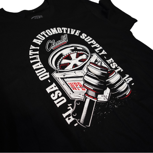 Close up of the front of a Cloud 9 black t-shirt showing crate graphic containing wheel and pair of air suspension struts.