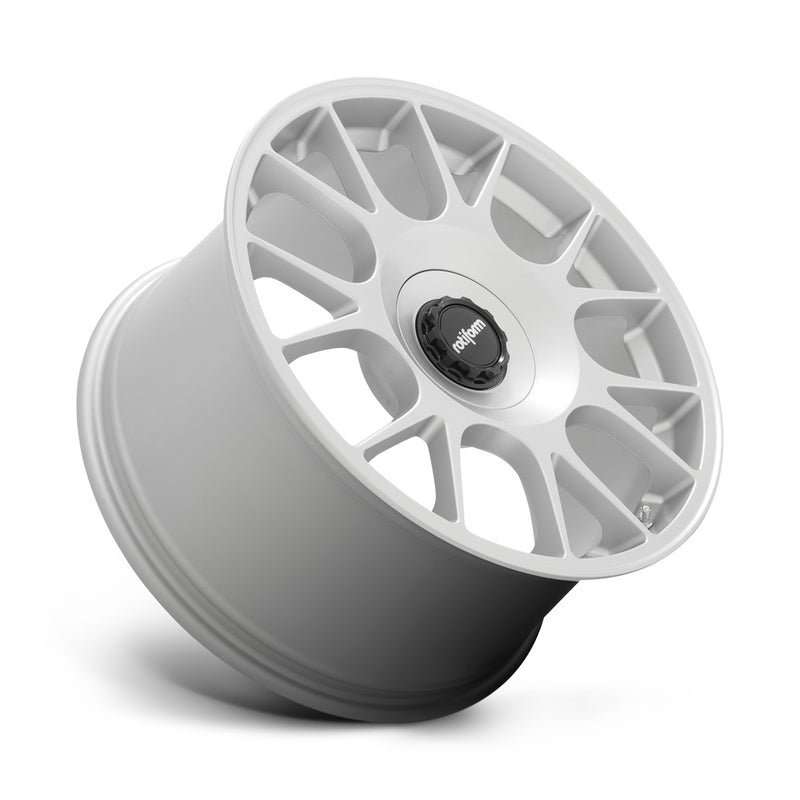 Tilted side view of a Rotiform TUF-R monoblock cast aluminum 7 spoke design automotive wheel in satin silver finish with a black center cap with a silver Rotiform logo.