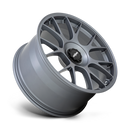 Tilted side view of a Rotiform TUF a monoblock forged aluminum 7 Y shape spoke automotive wheel in a satin titanium finish with the word Forged embossed in the bead ring and a black center cap with a silver Rotiform logo.