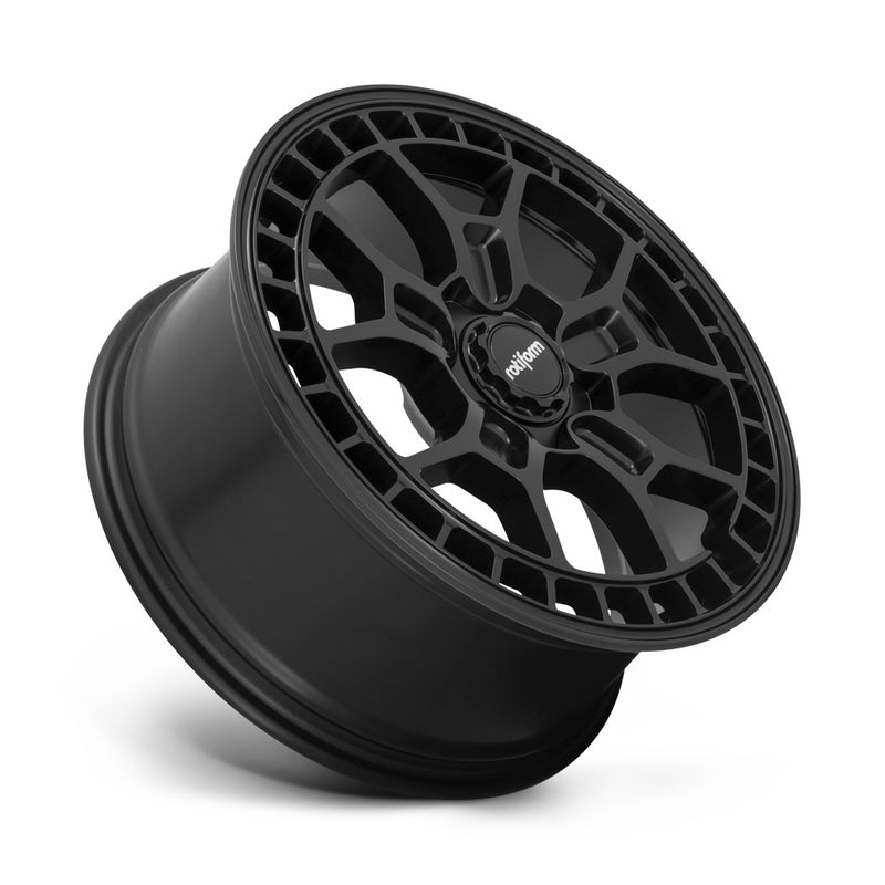 Tilted side view of a Rotiform ZMO-M monoblock cast aluminum 5 Y shape spoke automotive wheel in a matte black finish with a square hole pattern to the outer edge and a black center cap with a silver Rotiform logo.